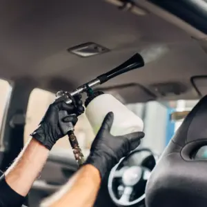 Reinigung eines Fahrzeugdachhimmels bei der professionellen Innenraumaufbereitung