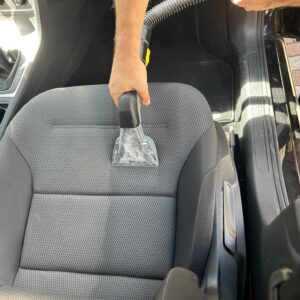 Reinigung eines Autositzes mit einem Waschsauger bei der professionellen Innenreinigung